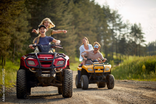 A group of happy friends posing for a photo while riding quads on the mountain. Riding, friendship, nature, activity