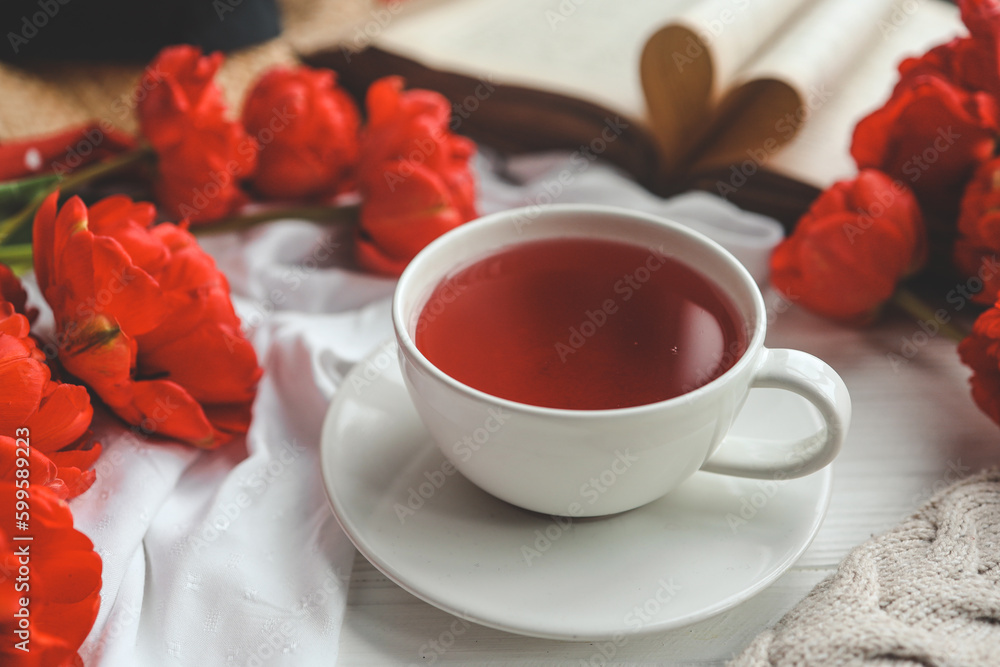 Beautiful spring composition, good morning concept. Cup of tea, peonies, open old book Beautiful spring composition, good morning concept. Cup of tea, peonies, open old book