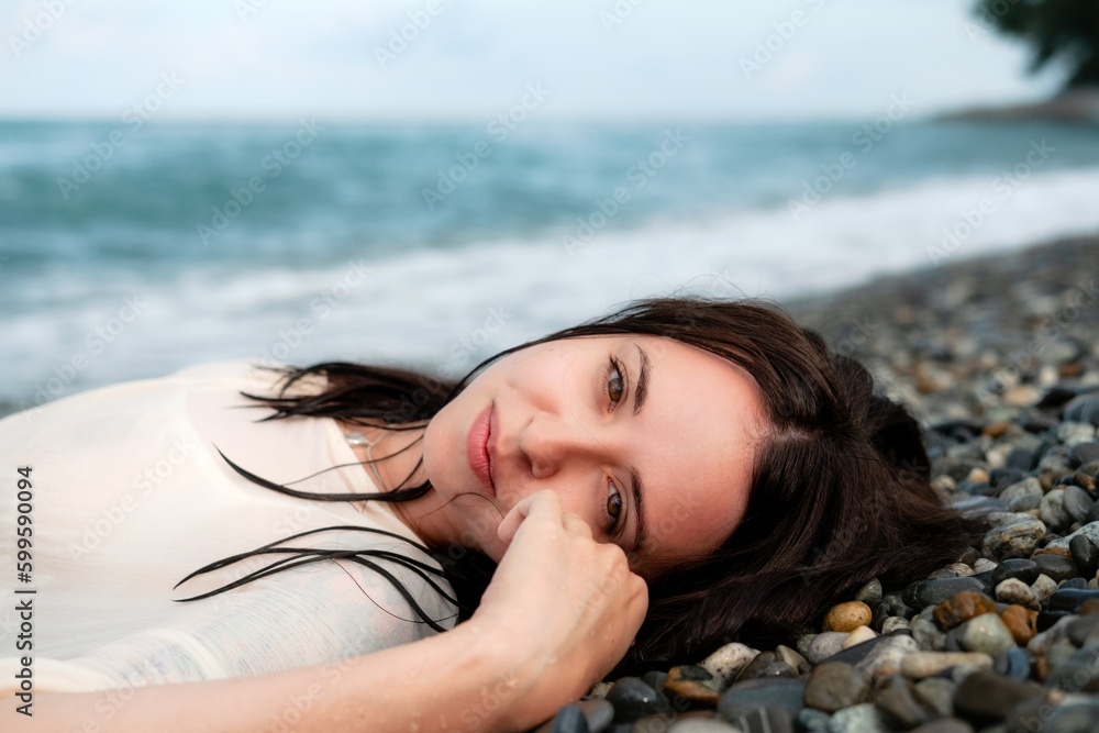 Charming woman lying on stony seashore Charming woman lying on stony seashore