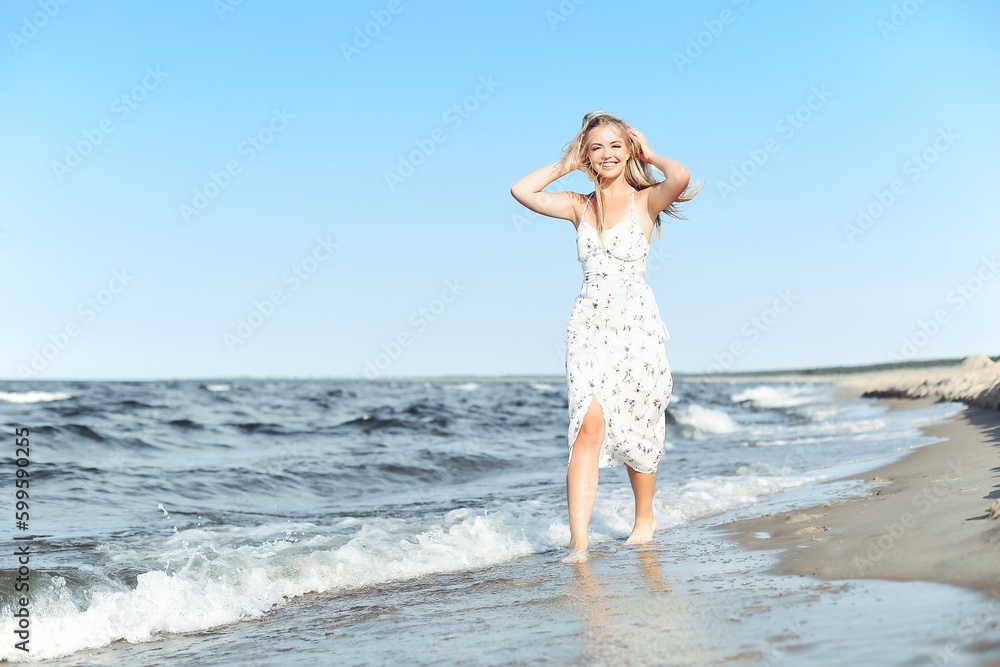 Happy blonde woman wearing sun glasses and relaxing on a wooden deck chair at the ocean beach Happy blonde woman wearing sun glasses and relaxing on a wooden deck chair at the ocean beach