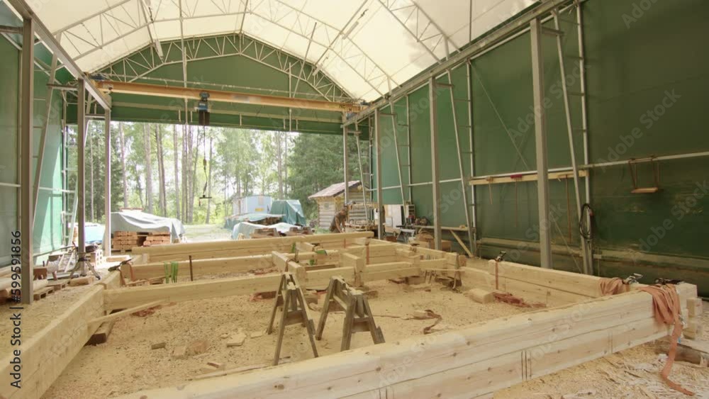 Wide shot of timber frame for log cabin being assembled in workshop Wide shot of timber frame for log cabin being assembled in workshop