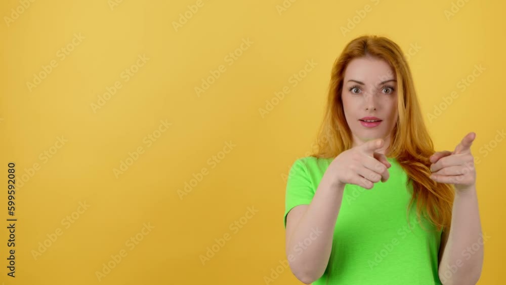 Woman and pointing at mockup workspace for advertisement, marketing, promotion or text. Female redhead model happy smiling showing mock up for news deal of offer in studio on yellow background Woman and pointing at mockup workspace for advertisement, marketing, promotion or text. Female redhead model happy smiling showing mock up for news deal of offer in studio on yellow background
