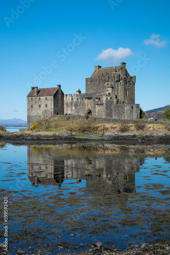 Eilean Donan castle reflected in the water on a sunny day