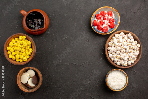 top view different candies with cookies on dark background flower color candy tea