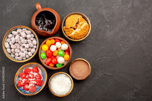top view different colorful candies with confitures on dark background color candy tea biscuit