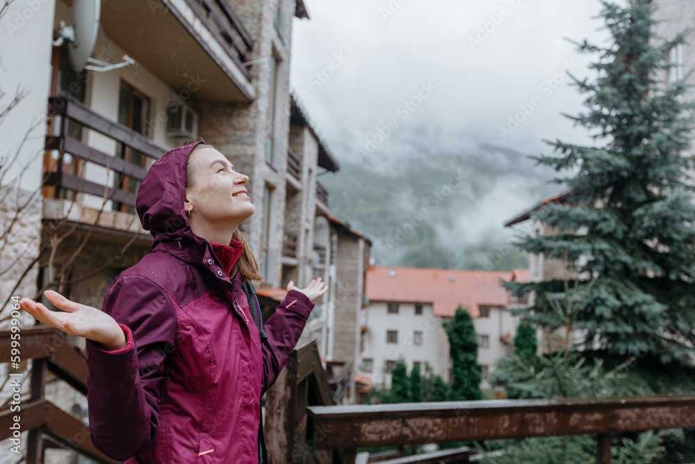 Young woman in a raincoat in the mountains. rainy weather.