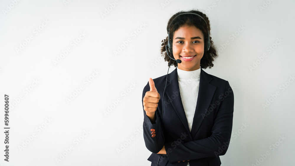 African american woman wearing headset and showing thumb up while talking customer in call center