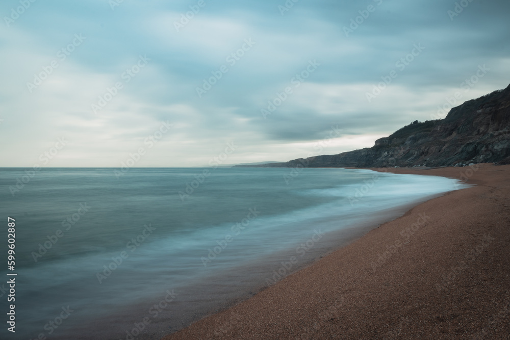 Long exposure of the blue sea on an empty coastline