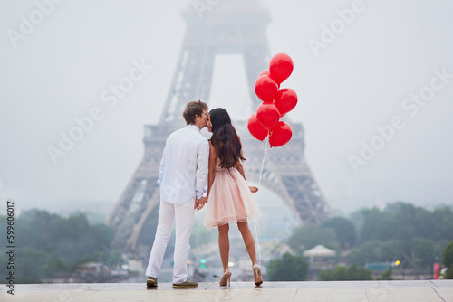 Romantic couple with red balloons together in Paris Fototapeta