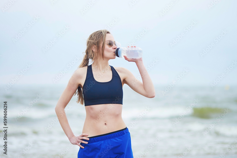 Runner girl drinking water from on running break Runner girl drinking water from on running break