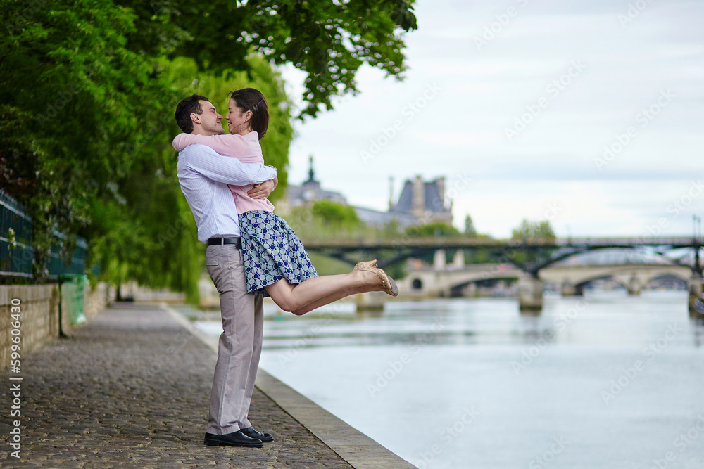 Couple is walking by the water in Paris