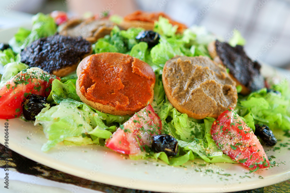 Delicious Provencal salad: fresh vegetables, olives, olive oil and toasts with different sorts of tapenade