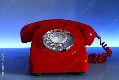 Red old fashiond dail telephone with a blue background