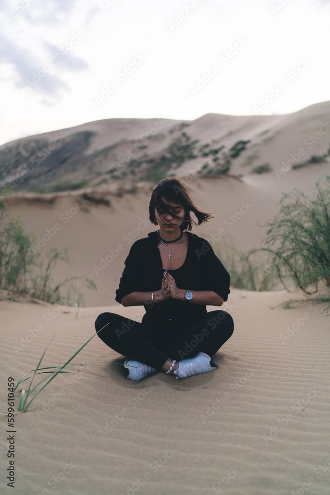 Focused woman meditating in desert valley