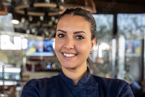 Obraz na plátně Young north african chef woman smiling on camera at the restaurant - Focus on fa