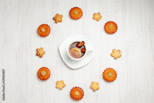 top view yummy little cakes lined with cookies and cup of tea on white background dessert biscuit tea cake pie cookie