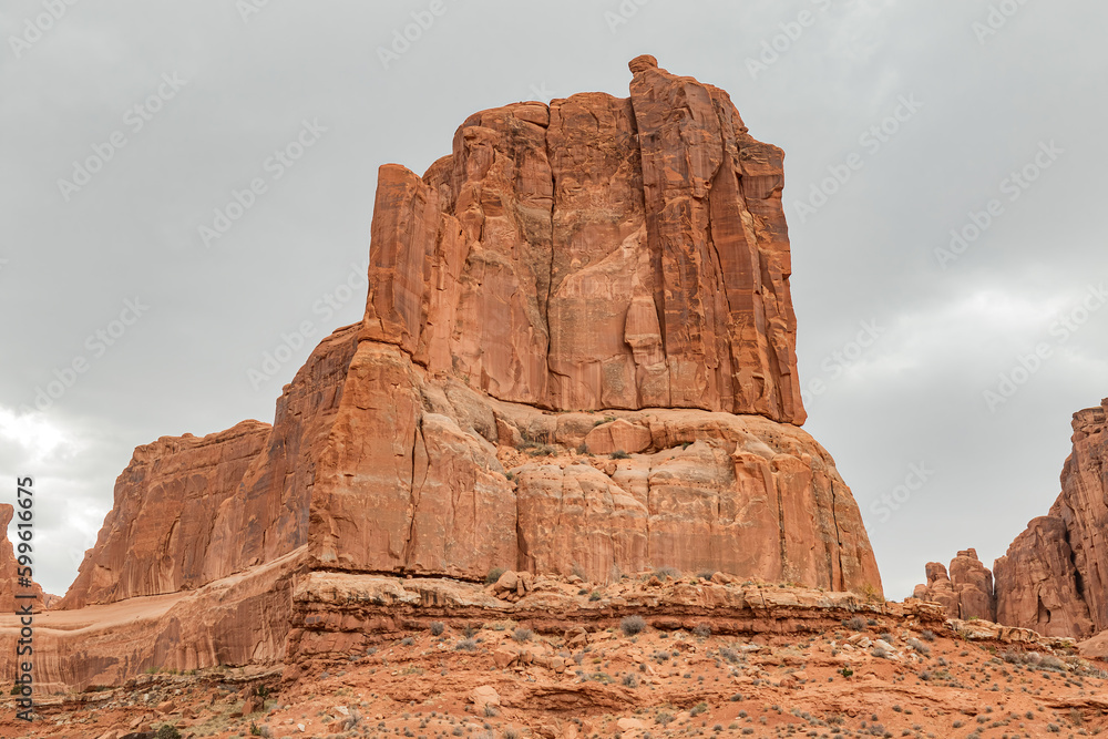 Red sandstone rock formation landscape in Arches National Park Utah on a cloudy day.