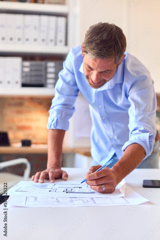 Mature Male Architect Working On Building Plans In Modern Office Mature Male Architect Working On Building Plans In Modern Office