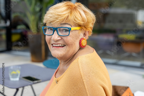 Portrait of a mature 80 years old smiling woman in glasses 