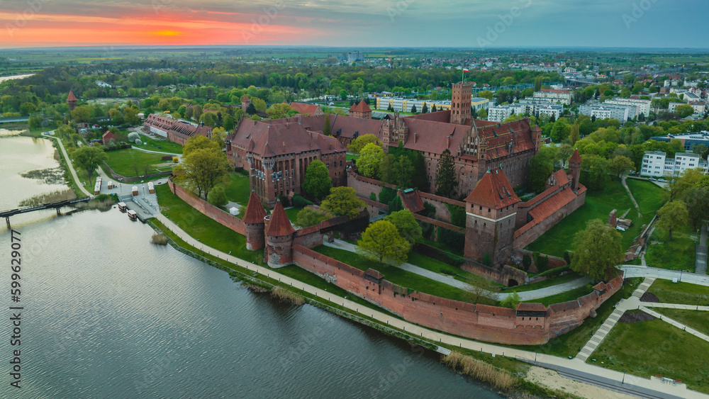 Teutonic Castle in Malbork. Majestic building and Nogat river in sunrise. Poland.