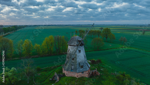 
An old Dutch windmill in the village of Palczewo in Żuławy, Poland. Spring morning. Drone view. photo