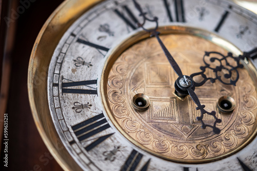 Old wooden clock with a pendulum hanging on the wall