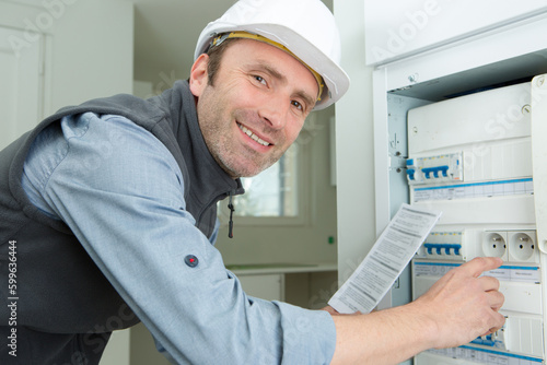 electrician posing next to electrical panel