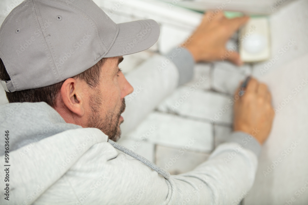 Fototapeta premium contractor installing surveillance cctv cameras in office