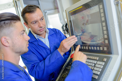 Two men looking at industrial computer screen