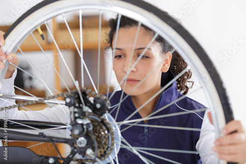 woman working on bike wheel