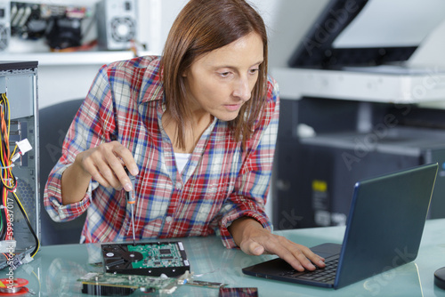 a woman unscrewing a laptopp photo