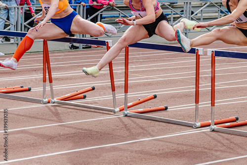 three woman runner running together 100 meters hurdles race in summer athletics championships