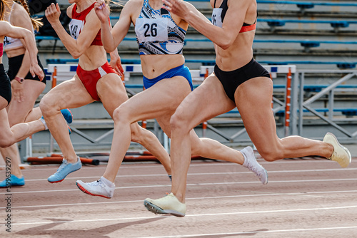 close-up legs female athlete runners running sprint race, summer athletics championships