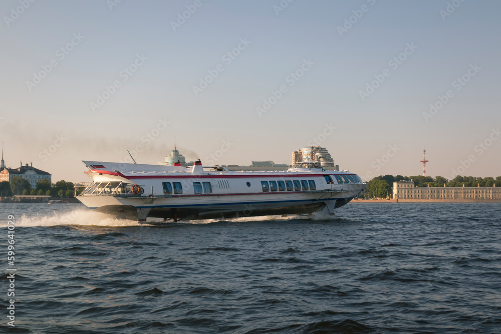 Soviet civil hydrofoil Meteor (superfast boat) on a river surface by warm summer day against clear blue sky