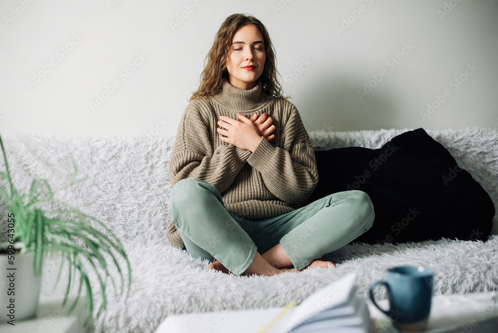 Relaxation techniques: Woman practicing pranayama in lotus position on bed, breathing exercises to reduce stress and anxiety, achieving inner balance and harmony, mindfulness and meditation practice - obrazy, fototapety, plakaty 