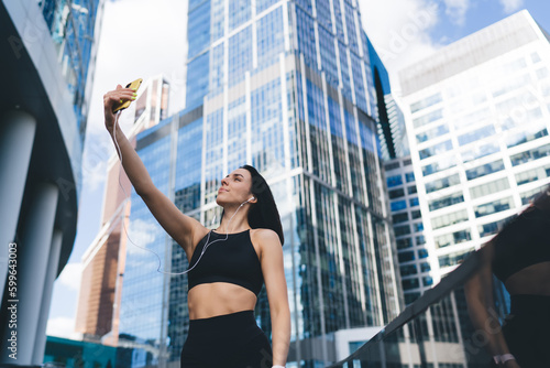 Confident sportswoman taking self portrait on smartphone