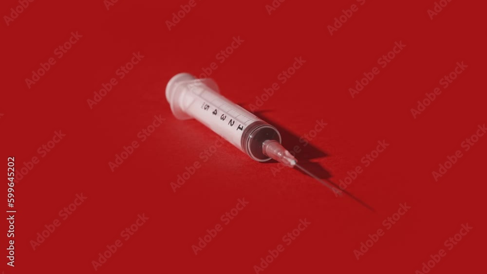 Medical syringe fills and empties on changing background Medical syringe fills and empties on changing background