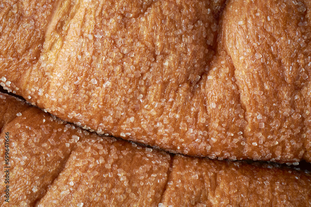 close-up macro view of surface of freshly baked sweet sugar coated bun, sprinkled sugar and toning, top view full frame food background 