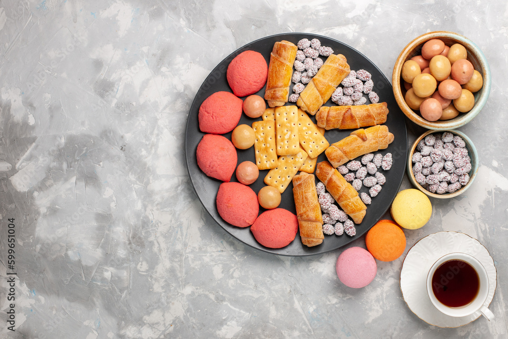 top view delicious cakes with cup of tea bagels crackers and candies on light-white desk cake biscuit cookie sweet sugar pie top view delicious cakes with cup of tea bagels crackers and candies on light-white desk cake biscuit cookie sweet sugar pie