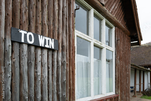 Shallow focus of a To Win sign seen attached to the wall of a timber built cricket pavilion in a rural English village. photo