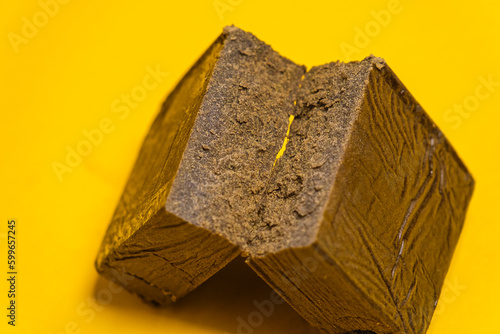 Chemdawg filtered hash. Medical marijuana extraction super dry hashish high quality cannabis pollen on a yellow background.