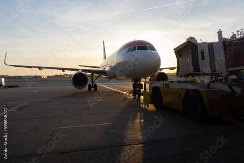 A jet bridge connecting to an airplane at sunset