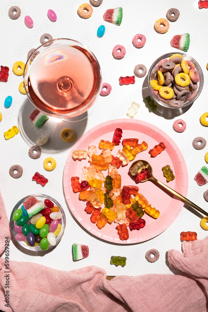 Plate with gummy bears, jelly beans and a glass with pink drink Plate with gummy bears, jelly beans and a glass with pink drink