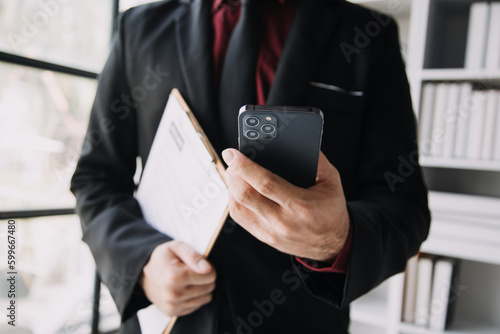 Businessman or job seeker review his resume on his desk before send to finding a new job with pen, necktie, glasses and digital tablet.
