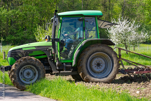 Close-up of green tractor  with female driver ploughing agriculture field at City of Z  rich on a sunny spring day. Photo taken May 4th  2023  Zurich  Switzerland.