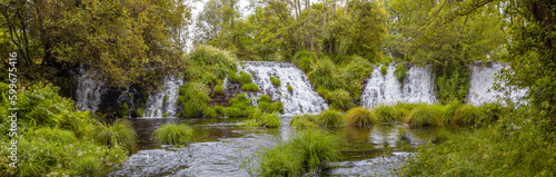 Panoramic landscape view of the Arenteiro waterfalls in Ourense, surrounded by green grasses in summer 2021 Spain