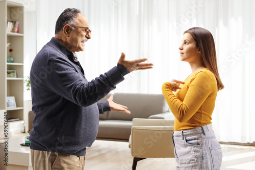 Tableau sur toile Profile shot of a father arguing with aughter at home