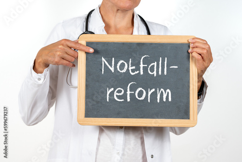 Ärztin zeigt auf eine Tafel auf der Notfallreform steht