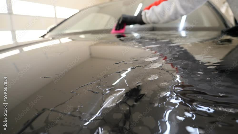 Close up to PPF installation process on a front headlight and hood. PPF