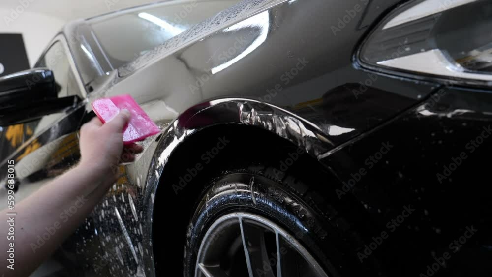 Close up to PPF installation process on a front headlight and hood. PPF ...